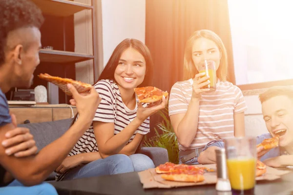 Mladí lidé jedí vynikající pizzu doma — Stock fotografie