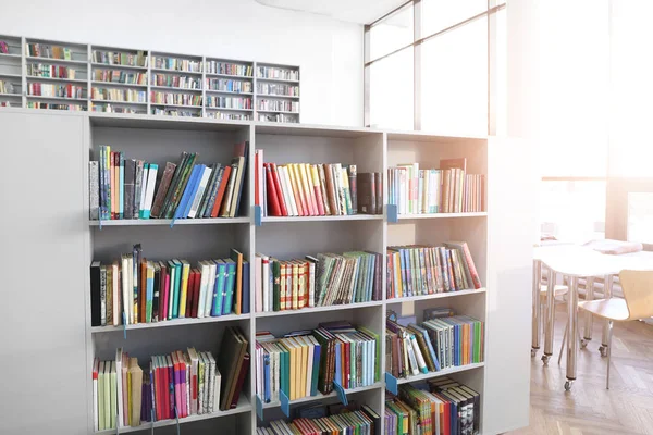 Many books on shelves in modern library — Stock Photo, Image