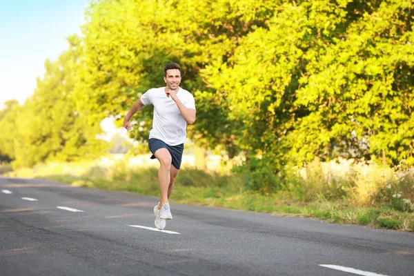 Sporty young man running outdoors — Stock Photo, Image