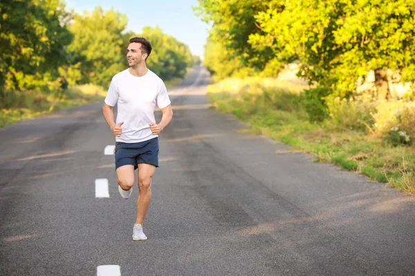 Sporty young man running outdoors — Stock Photo, Image