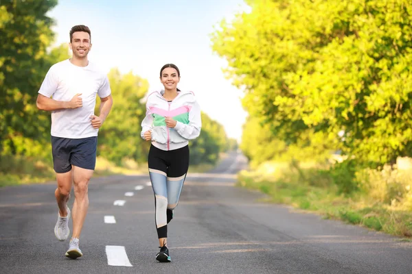 Deportiva joven pareja corriendo al aire libre — Foto de Stock