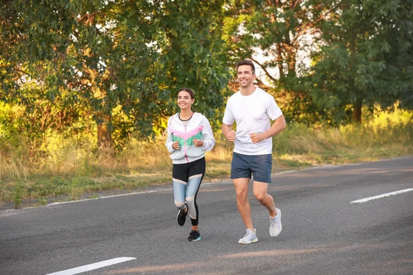 Deportiva joven pareja corriendo al aire libre — Foto de Stock