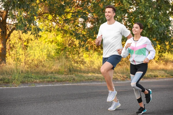 Sporty young couple running outdoors — Stock Photo, Image