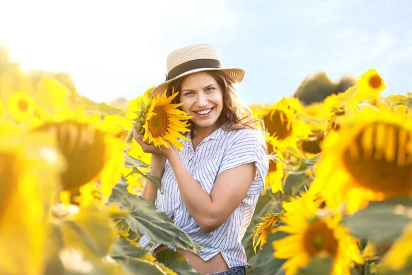 Beautiful young woman in sunflower field on summer day — Stock Photo, Image