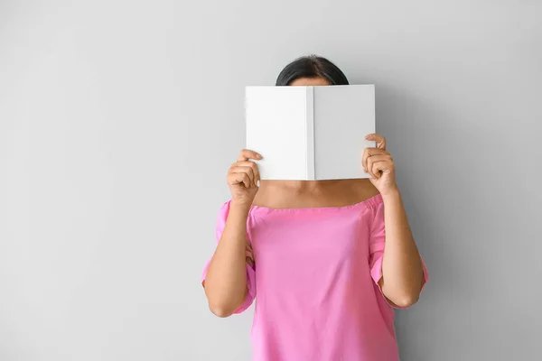 Bella donna con libro su sfondo chiaro — Foto Stock