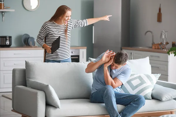 Angry wife scolding her husband at home — Stock Photo, Image