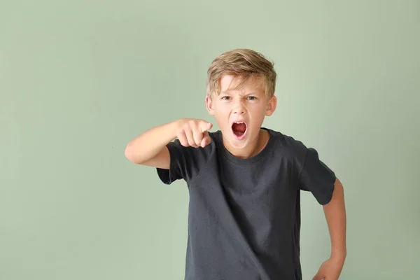 Portrait of angry little boy on color background — Stock Photo, Image