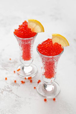 Beyaz masada kırmızı havyar ve limon ile Gözlük