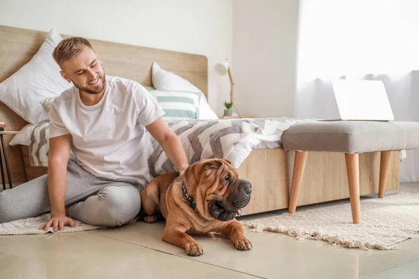 Happy man with cute dog in bedroom — Stock Photo, Image