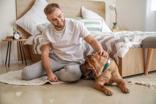 Счастливый мужчина с милой собакой в спальне — стоковое фото
