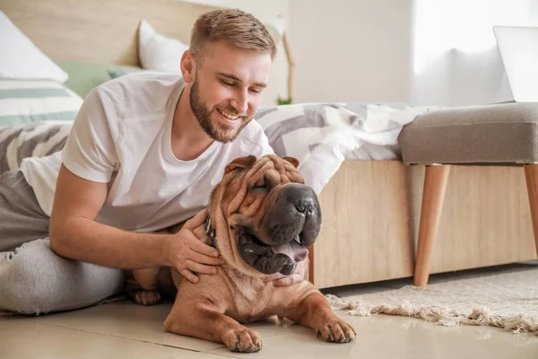 Hombre feliz con lindo perro en el dormitorio — Foto de Stock