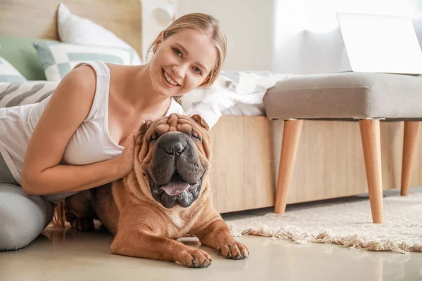 Mujer feliz con lindo perro en el dormitorio — Foto de Stock
