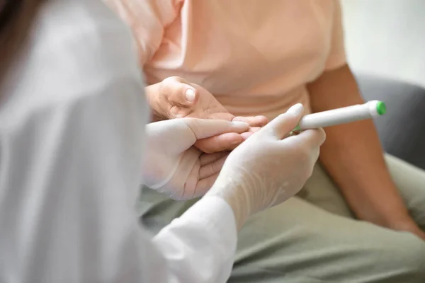 Doctor taking blood sample of diabetic woman at home, closeup — Stock Photo, Image