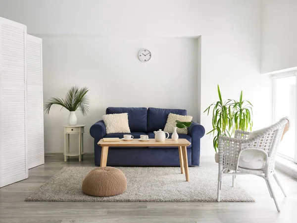 Wnętrze nowoczesnego pokoju z kanapą, stołem i kwiatowym wystrojem — Zdjęcie stockowe