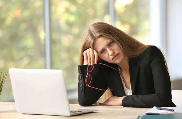 Stressed young woman at workplace — Stock Photo, Image