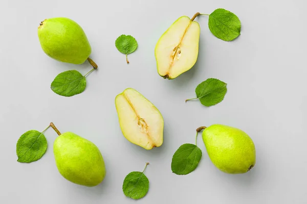 Tasty fresh pears with leaves on grey background — Stock Photo, Image