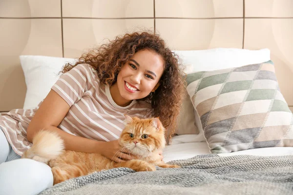 Joven mujer afroamericana con lindo gato en casa — Foto de Stock