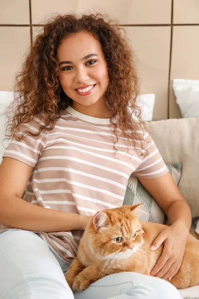 Jovem afro-americana com gato bonito em casa — Fotografia de Stock