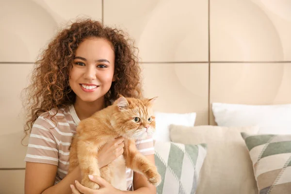 Jovem afro-americana com gato bonito em casa — Fotografia de Stock