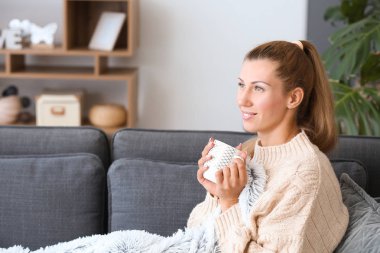 Güzel genç bayan evde kahve içiyor.