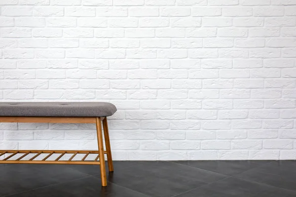 Comfortable bench near white brick wall — Stock Photo, Image