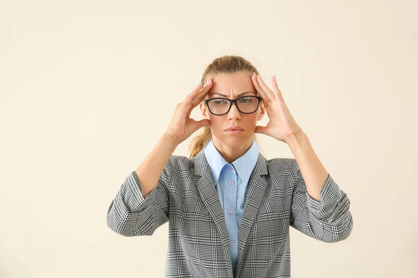 Stressed young businesswoman on light background