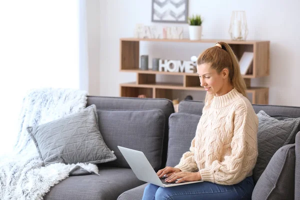 Beautiful young woman with laptop at home — Stock Photo, Image
