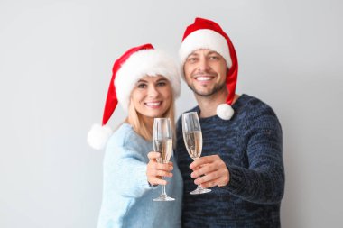 Santa şapkalar Mutlu çift ışık arka planda şampanya içme