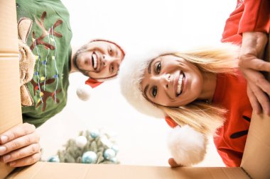 Noel Baba şapkalı mutlu çift Noel hediyesi açıyor, kutudan görünümü