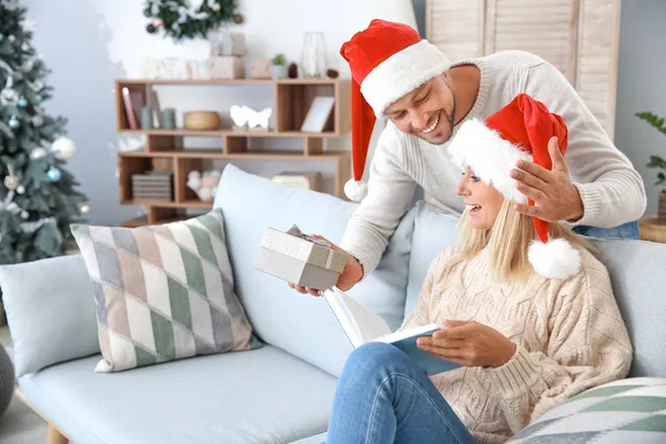 Man greeting his wife at home on Christmas eve — Stock Photo, Image