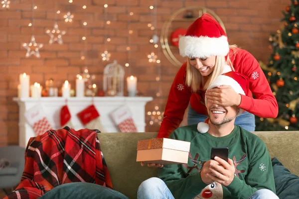 Frau begrüßt ihren Mann an Heiligabend zu Hause — Stockfoto