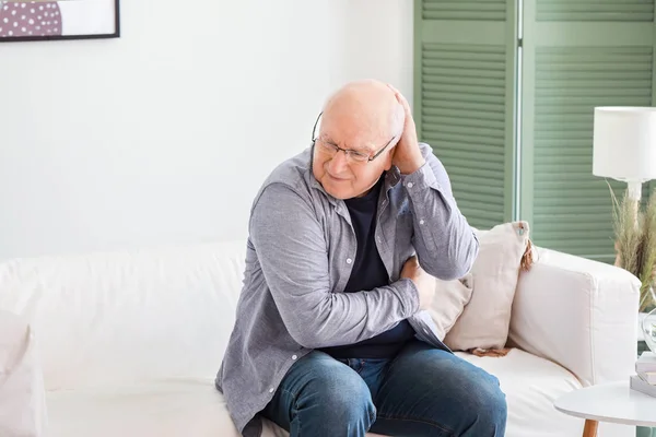 Senior man suffering from headache at home — Stock Photo, Image