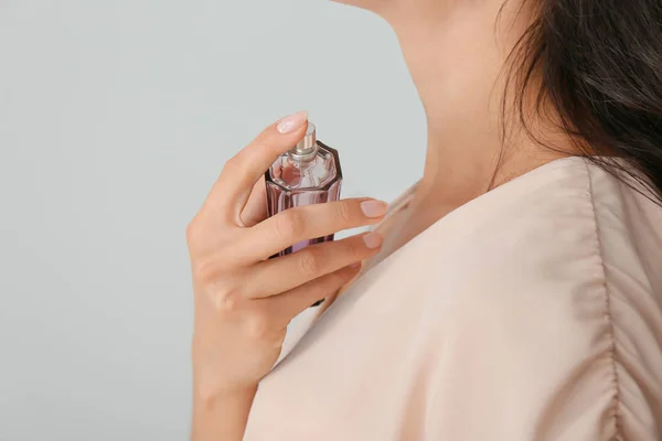 Açık renkli, closeup parfüm şişe güzel genç kadın — Stok fotoğraf