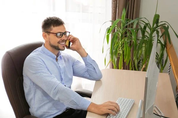 Businessman talking by mobile phone during work in office — Stock Photo, Image