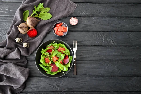 暗いテーブルの上においしいサラダとプレート — ストック写真