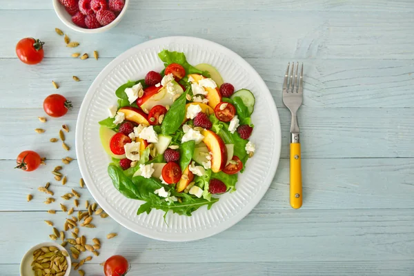 Plate with tasty salad on wooden table — Stock Photo, Image