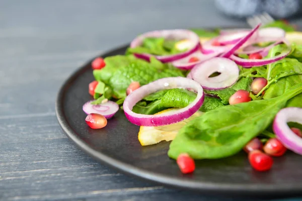 Tallrik med smakrik sallad på bordet, närbild — Stockfoto