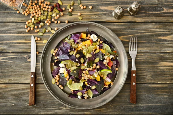 Тарілка зі смачним салатом на дерев'яному столі — стокове фото