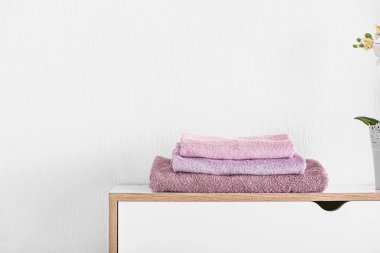 Stack of clean towels on table in room clipart
