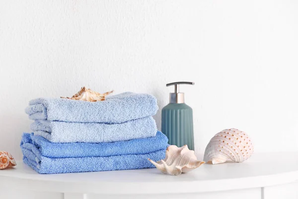 Stos czystych ręczników z mydłem i muszli na stole — Zdjęcie stockowe