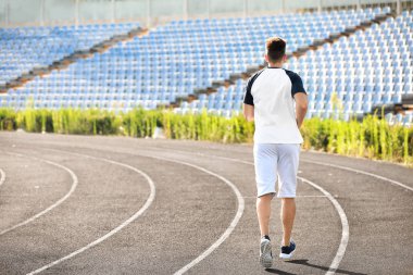 Sportif genç adam stadyumda çalışan