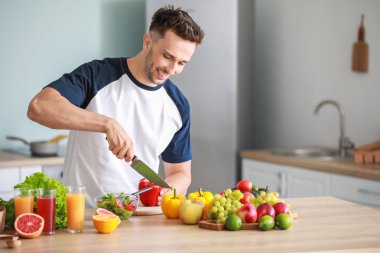 Mutfakta yemek pişiren sağlıklı ürünleri olan yakışıklı adam. Kilo kaybı kavramı