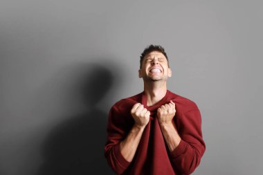 Gri arka planda kızgın adamın portresi