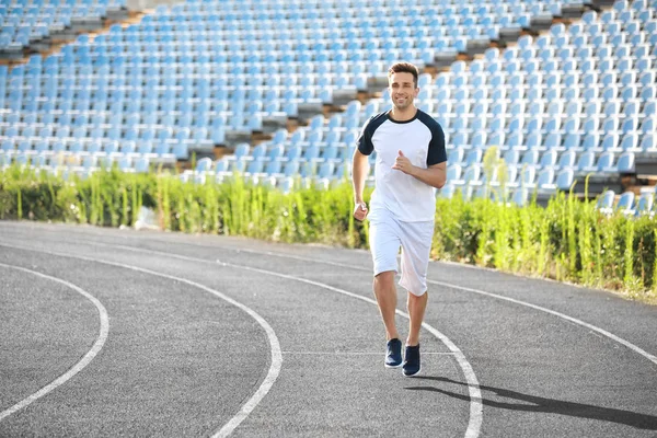 Sporty young man running at the stadium — Stock Photo, Image