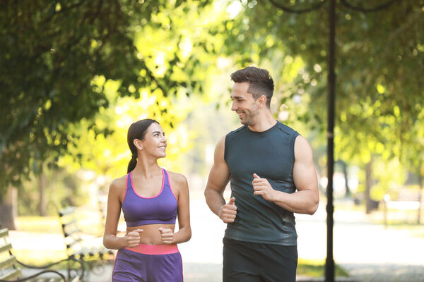 Спортивная молодая пара бегает в парке
