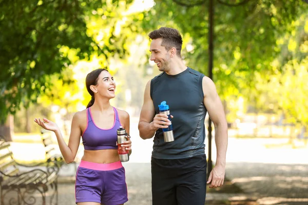 Desportivo jovem casal com garrafas de água no parque — Fotografia de Stock