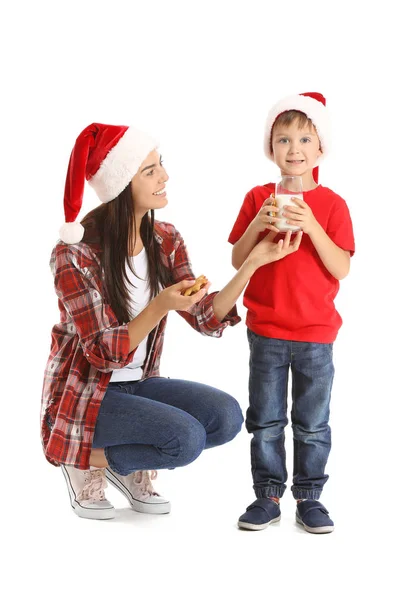Frau und ihr kleiner Sohn mit Milch und Weihnachtsplätzchen auf weißem Hintergrund — Stockfoto