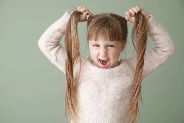 Portrait of angry little girl on color background — Stock Photo, Image