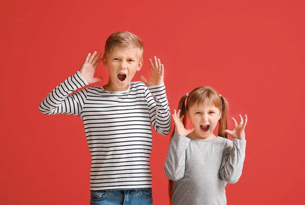 Portrait of angry little children on color background — Stock Photo, Image