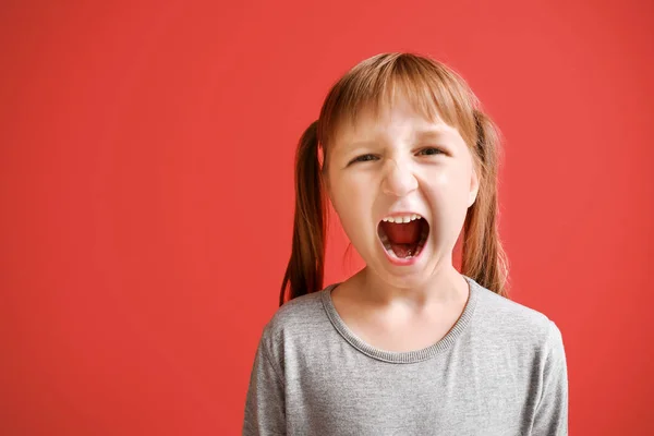 Portrait of angry little girl on color background — Stock Photo, Image